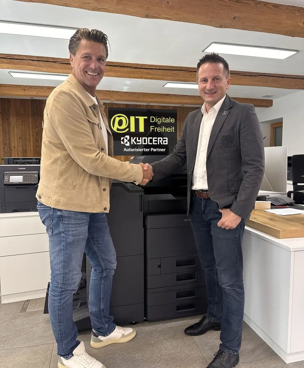 Ing. Martin Prenninger und Christian Ganglbauer beim Handschlag vor dem PIT-IT- und KYOCERA-Partnerschild